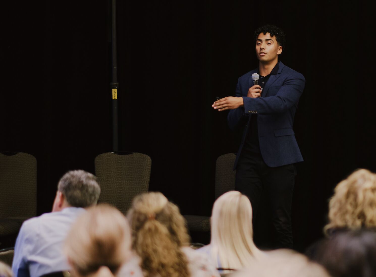 Christian Jackson speaking with a handheld microphone